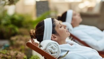 Shot of two women relaxing on deck chairs